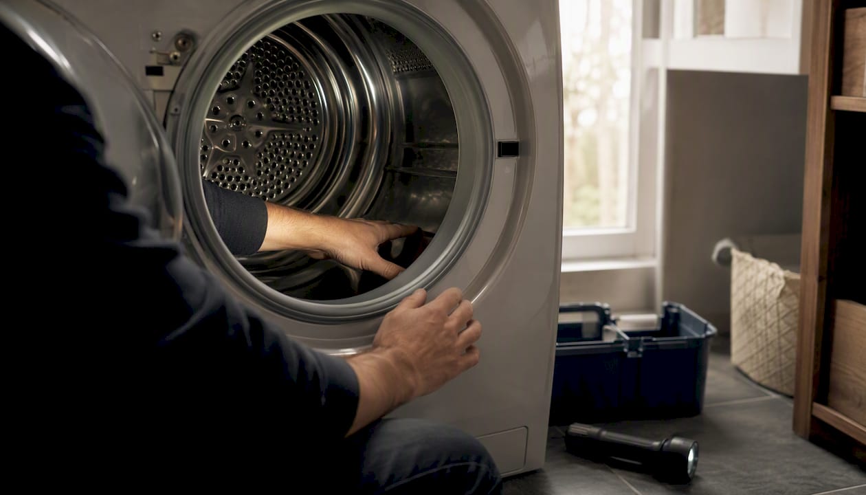 Hands inspecting inside dryer drum